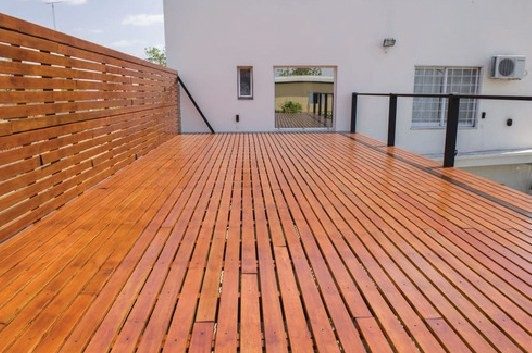 Deck de madera en terraza con baranda